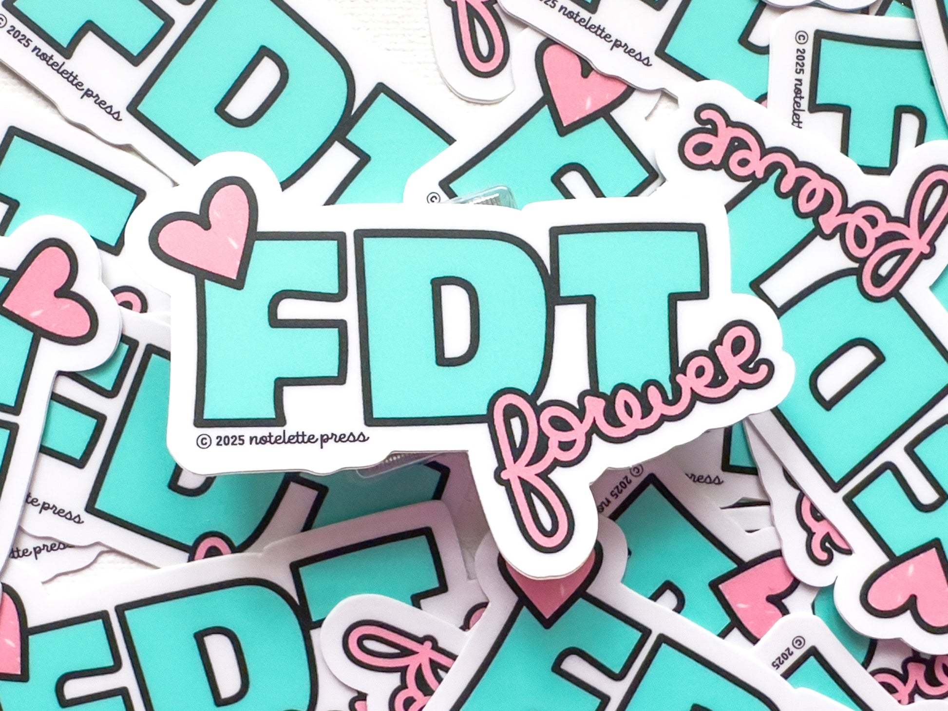 Stack of stickers with 'FDT forever' text and hearts on a white background