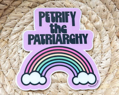 Sticker with rainbow and text 'PETRIFY THE PATRIARCHY' on a woven background